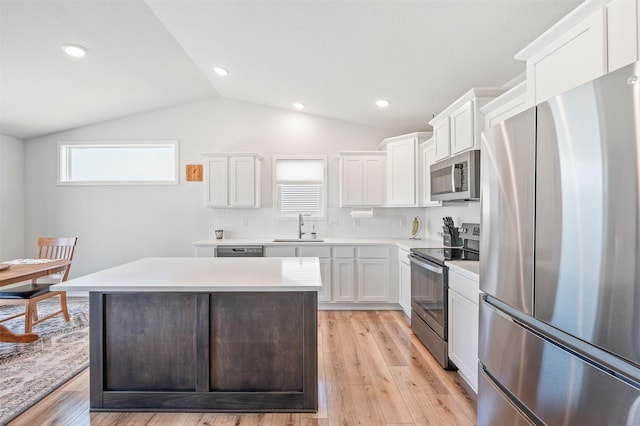 2708 NW Boulder Point Pl, Ankeny, IA 50023 - kitchen featuring appliances with stainless steel finishes, light wood-style floors, white cabinetry, light countertops, and vaulted ceiling