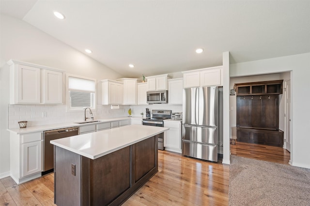 2708 NW Boulder Point Pl, Ankeny, IA 50023 - kitchen with stainless steel appliances, vaulted ceiling, white cabinetry, light wood-type flooring, and recessed lighting