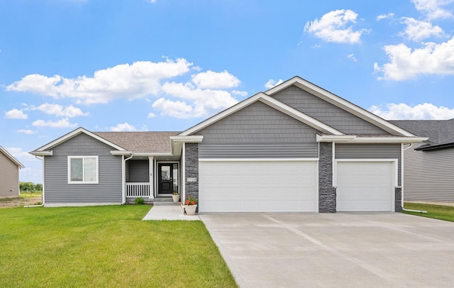 2708 NW Boulder Point Pl, Ankeny, IA 50023 - view of front of property featuring an attached garage, concrete driveway, a front lawn, stone siding, and covered porch