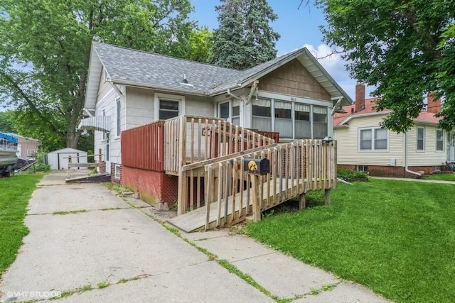 3617 E 8th St, Des Moines, IA 50316 - view of front of house featuring roof with shingles, a front lawn, a deck, and a shed