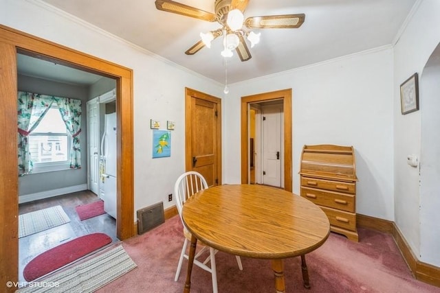 3617 E 8th St, Des Moines, IA 50316 - dining space with arched walkways, a ceiling fan, crown molding, and carpet floors