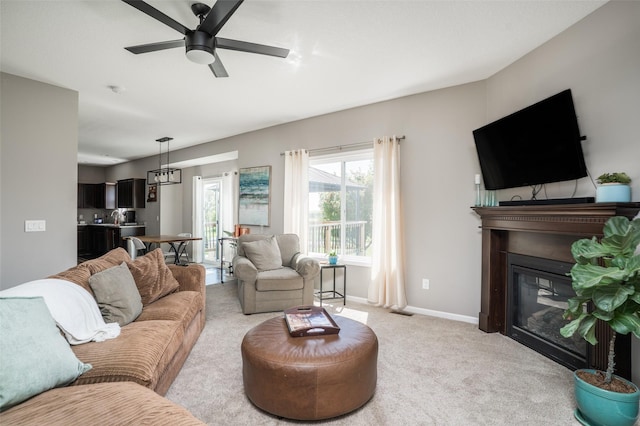 303 SE 14th St, Grimes, IA 50111 - living room featuring light colored carpet, a glass covered fireplace, and ceiling fan