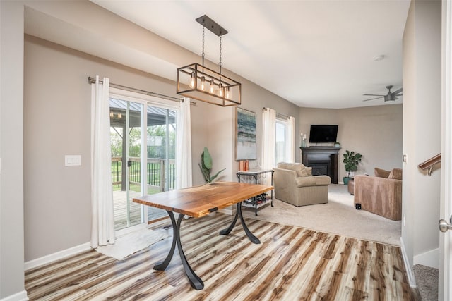 303 SE 14th St, Grimes, IA 50111 - dining room with a glass covered fireplace, light wood-style floors, and a ceiling fan