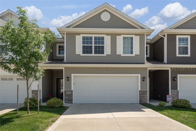 3213 NW Linwood Ln, Ankeny, IA 50023 - townhome / multi-family property with stone siding, an attached garage, and driveway