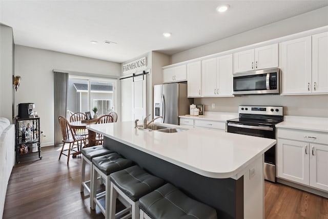 3213 NW Linwood Ln, Ankeny, IA 50023 - kitchen with stainless steel appliances, a kitchen breakfast bar, an island with sink, dark wood-type flooring, and recessed lighting
