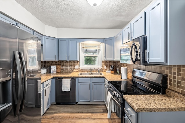 503 S Freeman St, Indianola, IA 50125 - kitchen with stainless steel appliances, wood finished floors, a textured ceiling, backsplash, and light countertops