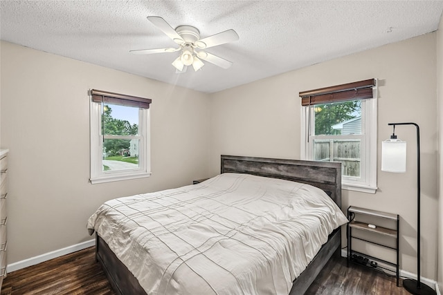 503 S Freeman St, Indianola, IA 50125 - bedroom with multiple windows, dark wood-style flooring, ceiling fan, and a textured ceiling