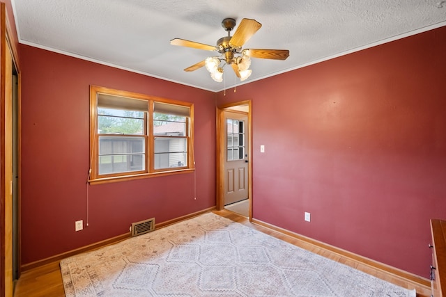 1232 Carrie Ave, Des Moines, IA 50315 - spare room with a ceiling fan, a textured ceiling, ornamental molding, and wood finished floors