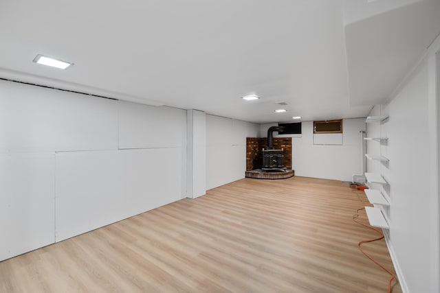 1232 Carrie Ave, Des Moines, IA 50315 - finished below grade area featuring a wood stove, wood finished floors, and recessed lighting