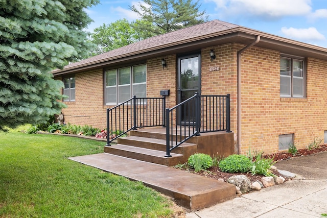 1232 Carrie Ave, Des Moines, IA 50315 - view of front of property with a front yard, brick siding, and roof with shingles