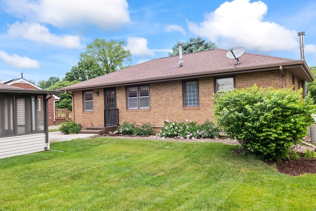 1232 Carrie Ave, Des Moines, IA 50315 - rear view of house with brick siding, a yard, and a shingled roof
