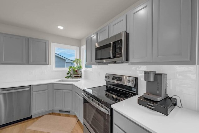 4412 NW 12th St, Ankeny, IA 50023 - kitchen with stainless steel appliances, gray cabinetry, decorative backsplash, light countertops, and recessed lighting