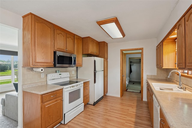106 NW Scott St, Ankeny, IA 50023 - kitchen with white appliances, light countertops, light wood finished floors, decorative backsplash, and brown cabinets