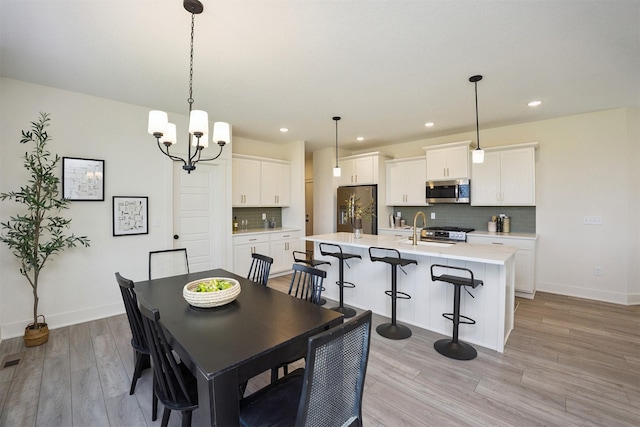 4774 172nd Way, Urbandale, IA 50323 - dining space with light wood-style floors, a chandelier, and recessed lighting