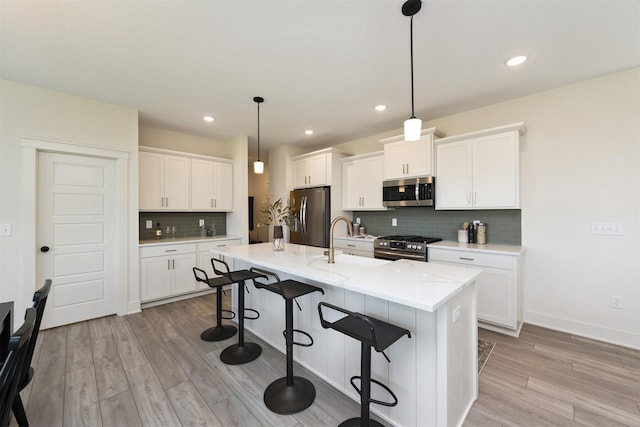 4774 172nd Way, Urbandale, IA 50323 - kitchen featuring stainless steel appliances, a kitchen breakfast bar, light wood-type flooring, decorative backsplash, and recessed lighting