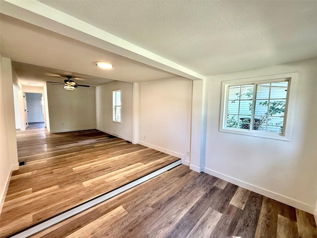 2011 E 23rd St, Des Moines, IA 50317 - empty room featuring a textured ceiling, wood finished floors, and a ceiling fan