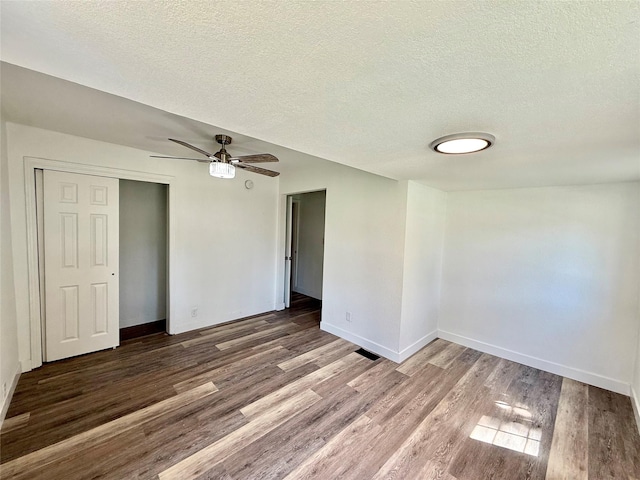 2011 E 23rd St, Des Moines, IA 50317 - unfurnished bedroom featuring wood finished floors, a textured ceiling, a closet, and a ceiling fan