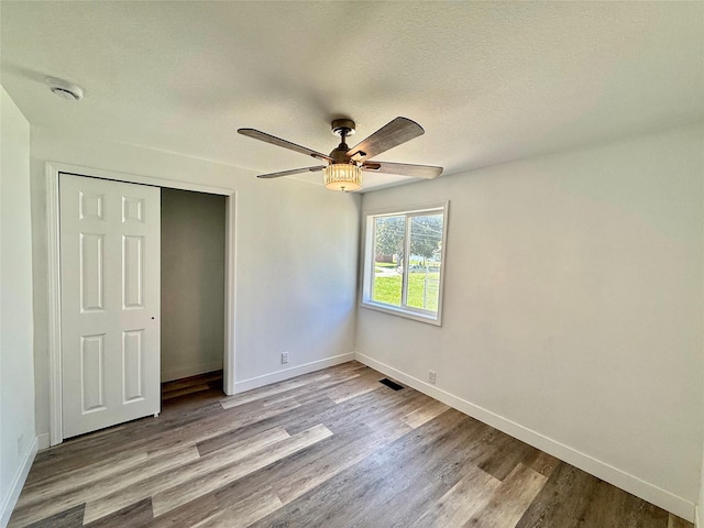 2011 E 23rd St, Des Moines, IA 50317 - unfurnished bedroom featuring wood finished floors, a closet, and ceiling fan