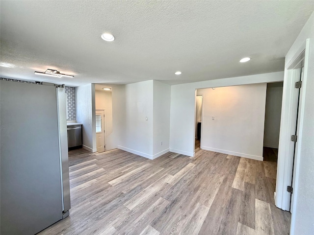 2011 E 23rd St, Des Moines, IA 50317 - basement with freestanding refrigerator, a textured ceiling, wood finished floors, and recessed lighting