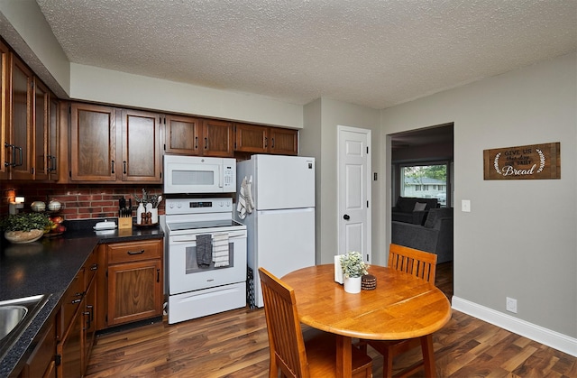 1802 W 5th Ave, Indianola, IA 50125 - kitchen featuring white appliances, dark wood-type flooring, decorative backsplash, dark countertops, and a textured ceiling