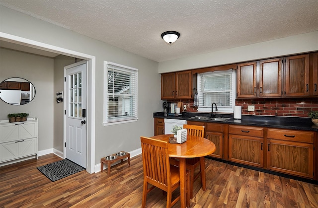 1802 W 5th Ave, Indianola, IA 50125 - kitchen featuring dark wood-style flooring, dark countertops, dishwasher, a textured ceiling, and decorative backsplash