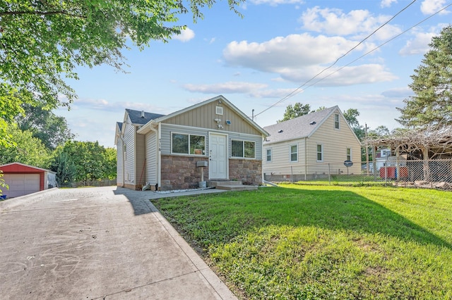 714 E 27th St, Des Moines, IA 50317 - view of front facade with board and batten siding, stone siding, an outdoor structure, a detached garage, and concrete driveway