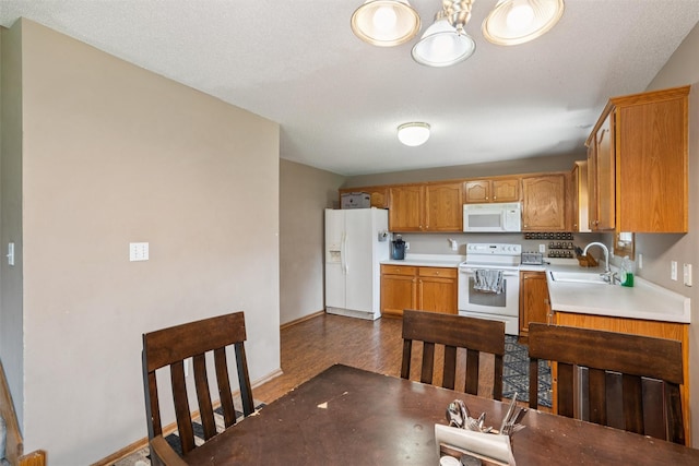 5428 NW 90th St, Johnston, IA 50131 - kitchen with white appliances, light countertops, a chandelier, dark wood-style floors, and brown cabinetry