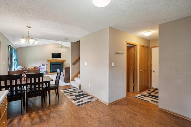 5428 NW 90th St, Johnston, IA 50131 - dining space featuring wood finished floors, stairs, a textured ceiling, vaulted ceiling, and a chandelier