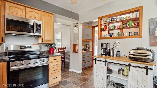 122 W Washington St, Colfax, IA 50054 - kitchen featuring appliances with stainless steel finishes, dark countertops, and light brown cabinets