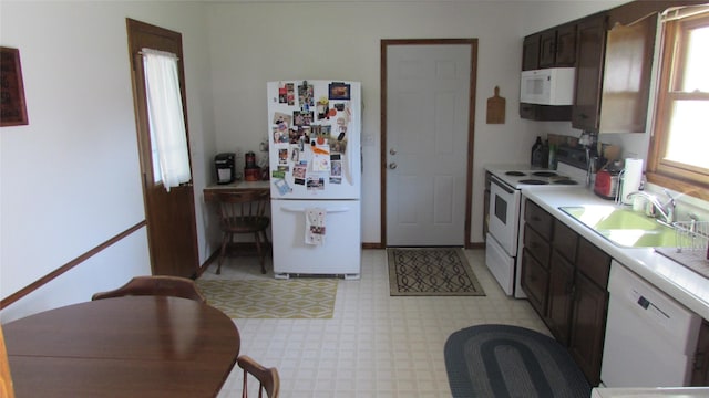 1401 N Grant St, Knoxville, IA 50138 - kitchen featuring white appliances, light floors, light countertops, and dark brown cabinets