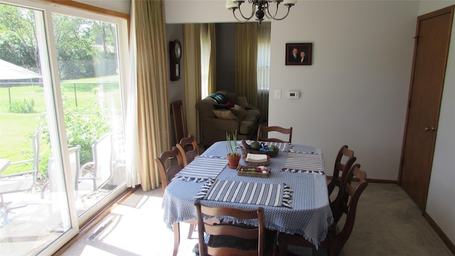 1401 N Grant St, Knoxville, IA 50138 - dining area featuring light carpet, plenty of natural light, and a chandelier
