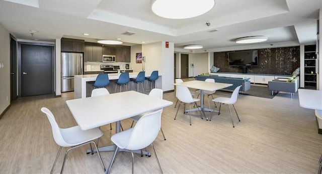 300 Walnut St Unit 1505, Des Moines, IA 50309 - dining room with a tray ceiling and light wood-style flooring