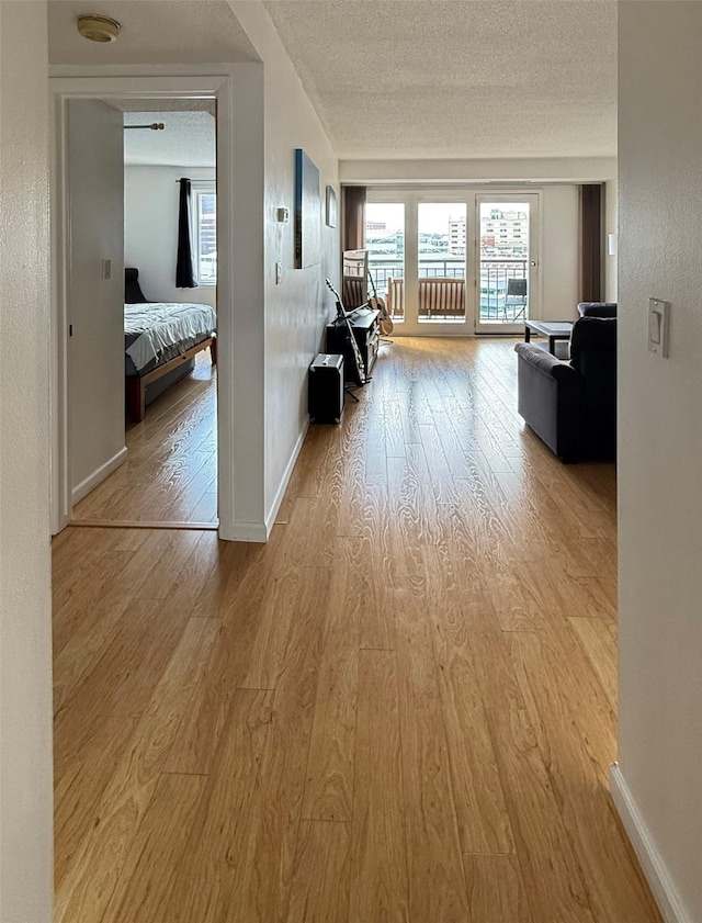 300 Walnut St Unit 1505, Des Moines, IA 50309 - corridor featuring wood finished floors and a textured ceiling