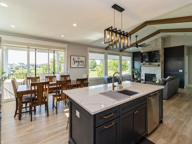 2013 Autumn Blaze Dr, Norwalk, IA 50211 - kitchen featuring stainless steel dishwasher, ceiling fan, a large fireplace, open floor plan, and light wood finished floors