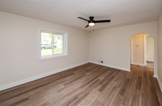3912 53rd St, Des Moines, IA 50310 - empty room featuring a ceiling fan, arched walkways, wood finished floors, and a textured ceiling