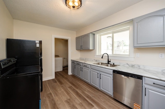 3912 53rd St, Des Moines, IA 50310 - kitchen featuring stainless steel dishwasher, gray cabinetry, freestanding refrigerator, light wood finished floors, and a textured ceiling