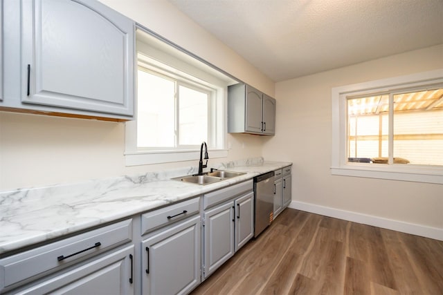 3912 53rd St, Des Moines, IA 50310 - kitchen featuring stainless steel dishwasher, wood finished floors, healthy amount of natural light, light countertops, and a textured ceiling