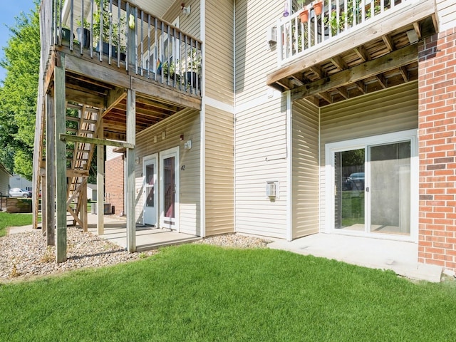 1106 N 6th St Unit 42, Indianola, IA 50125 - rear view of property featuring a balcony, a yard, stairway, and brick siding