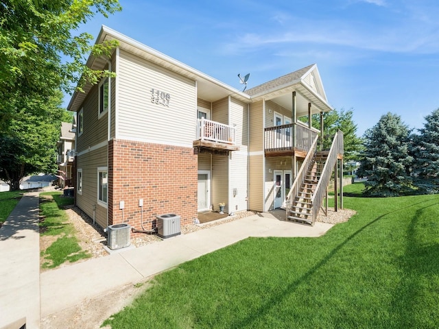 1106 N 6th St Unit 42, Indianola, IA 50125 - back of house featuring brick siding, a lawn, stairs, and a deck