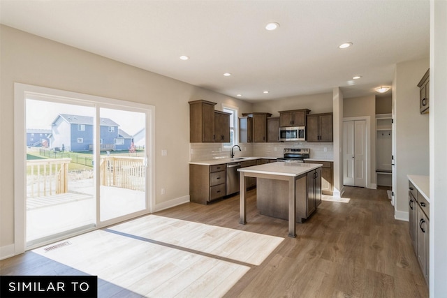 3601 NW 27th St, Ankeny, IA 50023 - kitchen featuring stainless steel appliances, a kitchen island, light countertops, decorative backsplash, and plenty of natural light