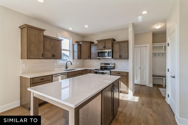 3601 NW 27th St, Ankeny, IA 50023 - kitchen with appliances with stainless steel finishes, backsplash, light wood-style flooring, a kitchen island, and recessed lighting