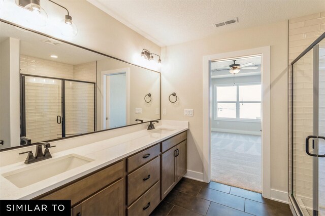 3601 NW 27th St, Ankeny, IA 50023 - full bathroom featuring double vanity, a ceiling fan, a stall shower, tile patterned flooring, and a textured ceiling