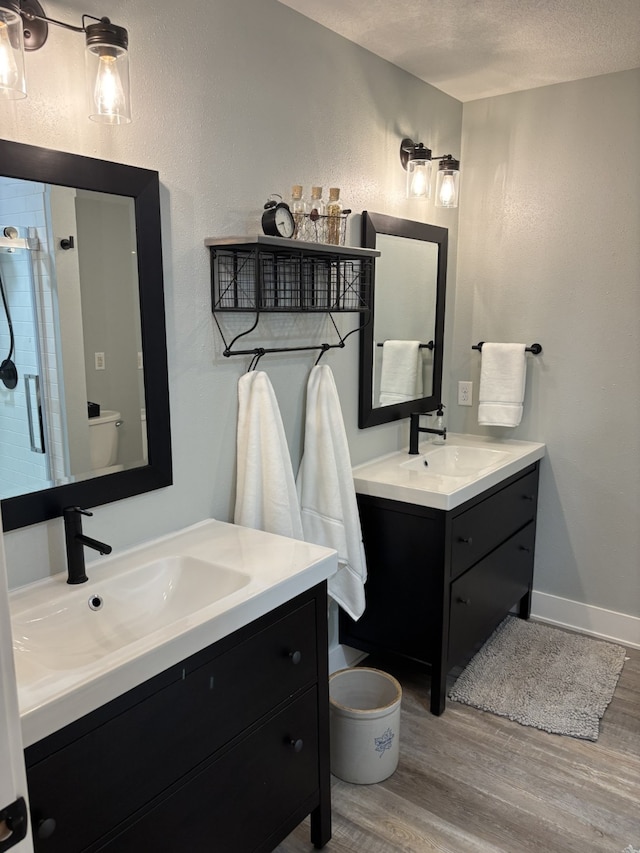 8200 Goodman Dr, Urbandale, IA 50322 - full bath featuring wood finished floors, vanity, a shower stall, and a textured ceiling