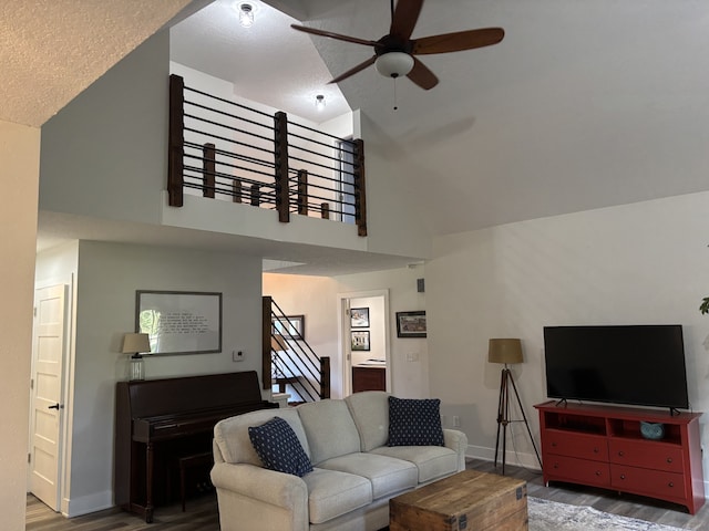 8200 Goodman Dr, Urbandale, IA 50322 - living room featuring ceiling fan, wood finished floors, high vaulted ceiling, stairs, and a textured ceiling
