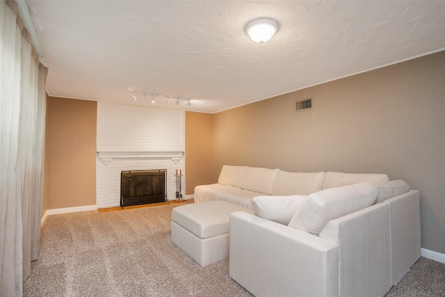 5625 Kingman Ave, Des Moines, IA 50311 - living area with light colored carpet, a brick fireplace, and rail lighting