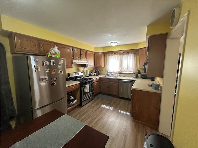 607 E Jasper St, Pleasantville, IA 50225 - kitchen with appliances with stainless steel finishes, under cabinet range hood, light countertops, and light wood-style floors