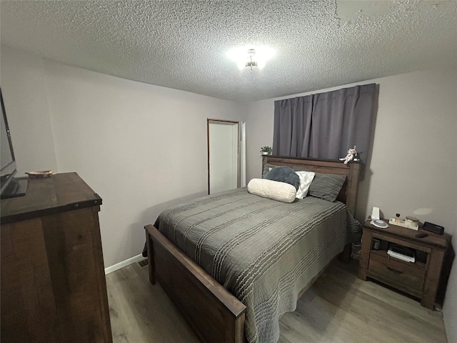 607 E Jasper St, Pleasantville, IA 50225 - bedroom featuring light wood-type flooring and a textured ceiling
