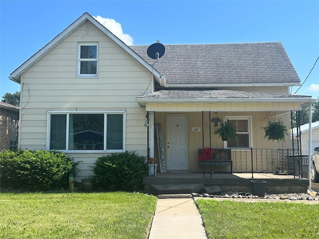 607 E Jasper St, Pleasantville, IA 50225 - view of front facade featuring covered porch, a front lawn, and a shingled roof
