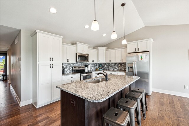629 Mallard Pointe Dr NW, Bondurant, IA 50035 - kitchen featuring stainless steel appliances, vaulted ceiling, backsplash, a center island with sink, and white cabinets
