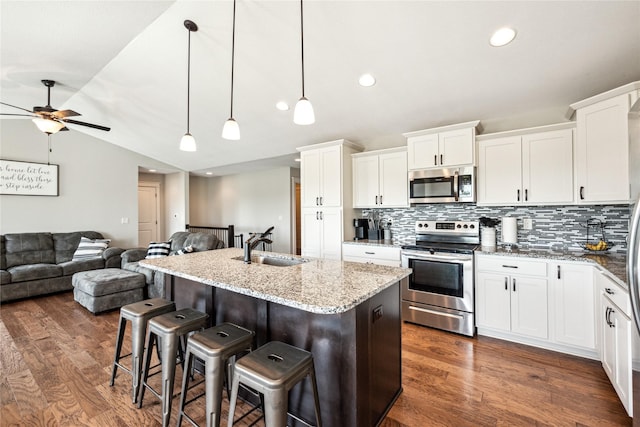 629 Mallard Pointe Dr NW, Bondurant, IA 50035 - kitchen with stainless steel appliances, vaulted ceiling, ceiling fan, open floor plan, and tasteful backsplash